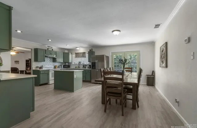 a kitchen with a table chairs and wooden floor
