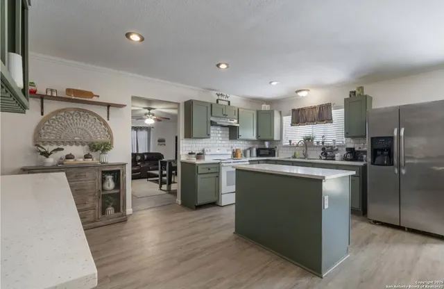 a kitchen with granite countertop a refrigerator stove top oven and sink
