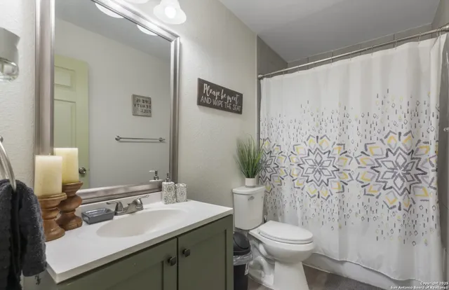 a bathroom with a toilet sink and mirror