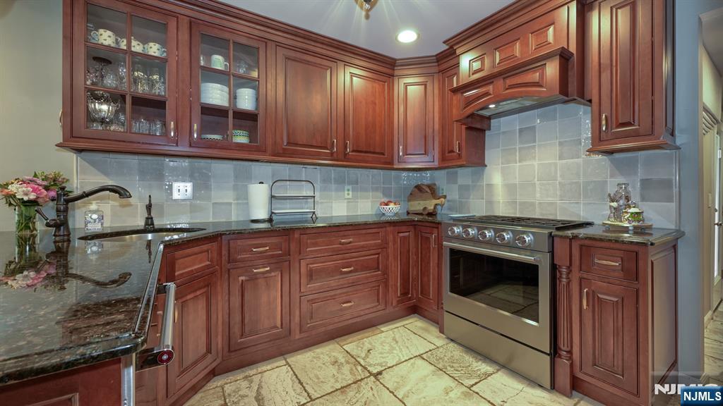 23 Erli Street Wayne, NJ 07470 - Photo 14 of 49 a kitchen with stainless steel appliances granite countertop a stove and cabinets