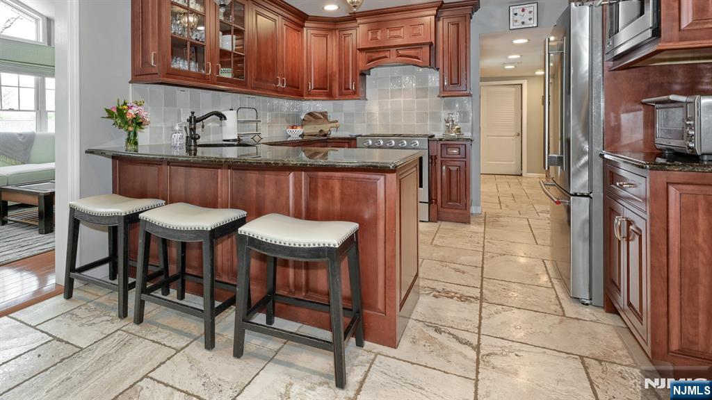 23 Erli Street Wayne, NJ 07470 - Photo 16 of 49 a kitchen with stainless steel appliances a sink a stove a table and chairs