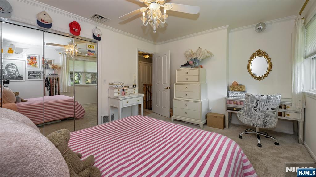 23 Erli Street Wayne, NJ 07470 - Photo 31 of 49 a bedroom with a bed and a chandelier