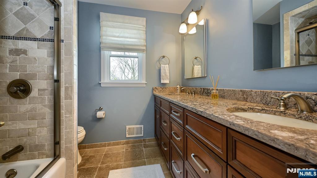 23 Erli Street Wayne, NJ 07470 - Photo 32 of 49 a bathroom with a granite countertop sink a toilet a mirror and shower