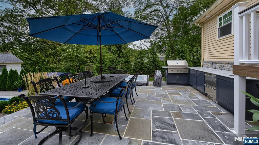 23 Erli Street Wayne, NJ 07470 - Photo 41 of 49 a patio with a table and chairs under an umbrella