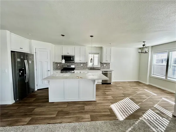 a kitchen with stainless steel appliances granite countertop a refrigerator stove top oven and sink