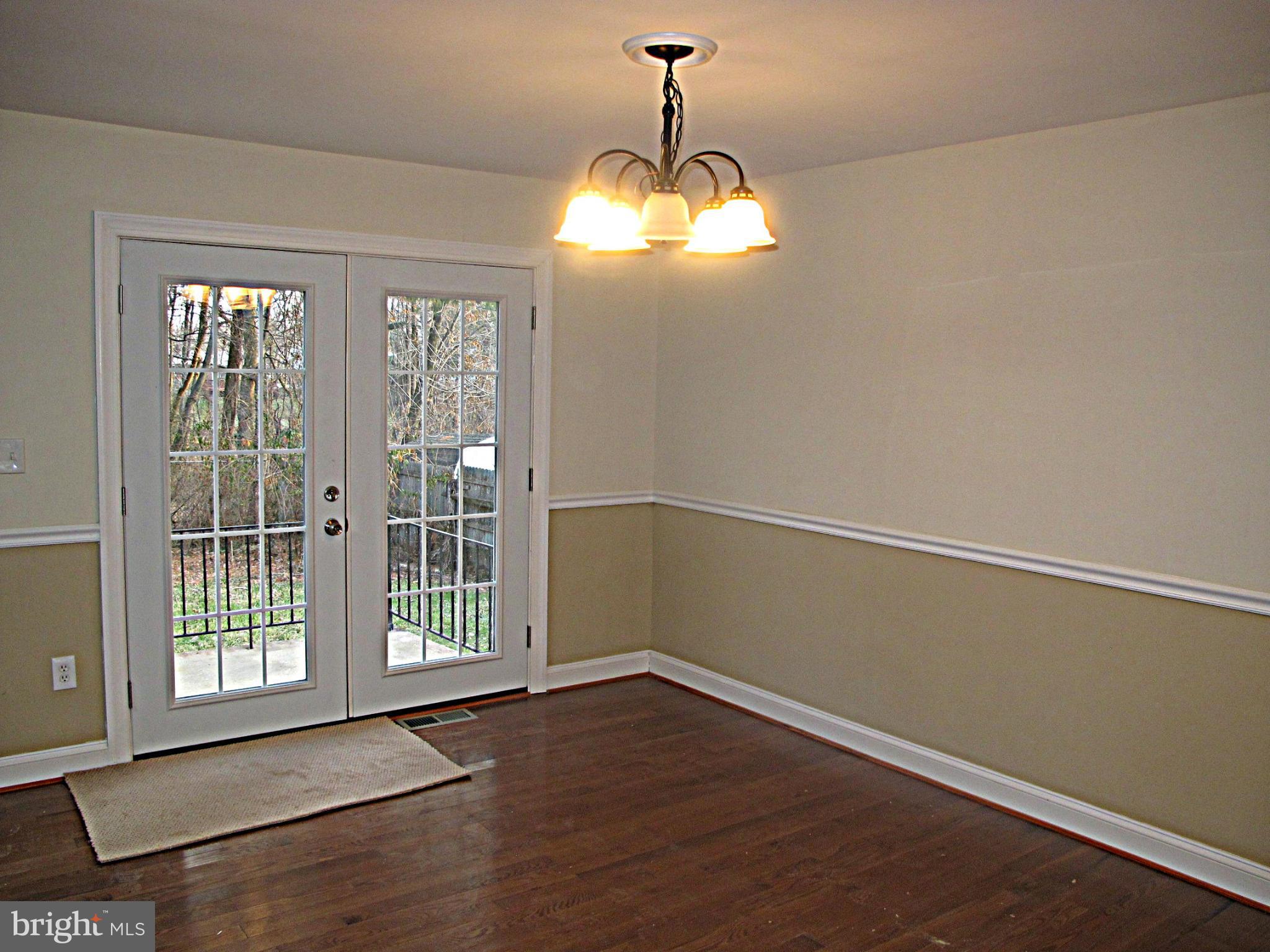 8910 Maplebrook Road Randallstown, MD 21133 - Photo 4 of 18 a view of an empty room with wooden floor and a window