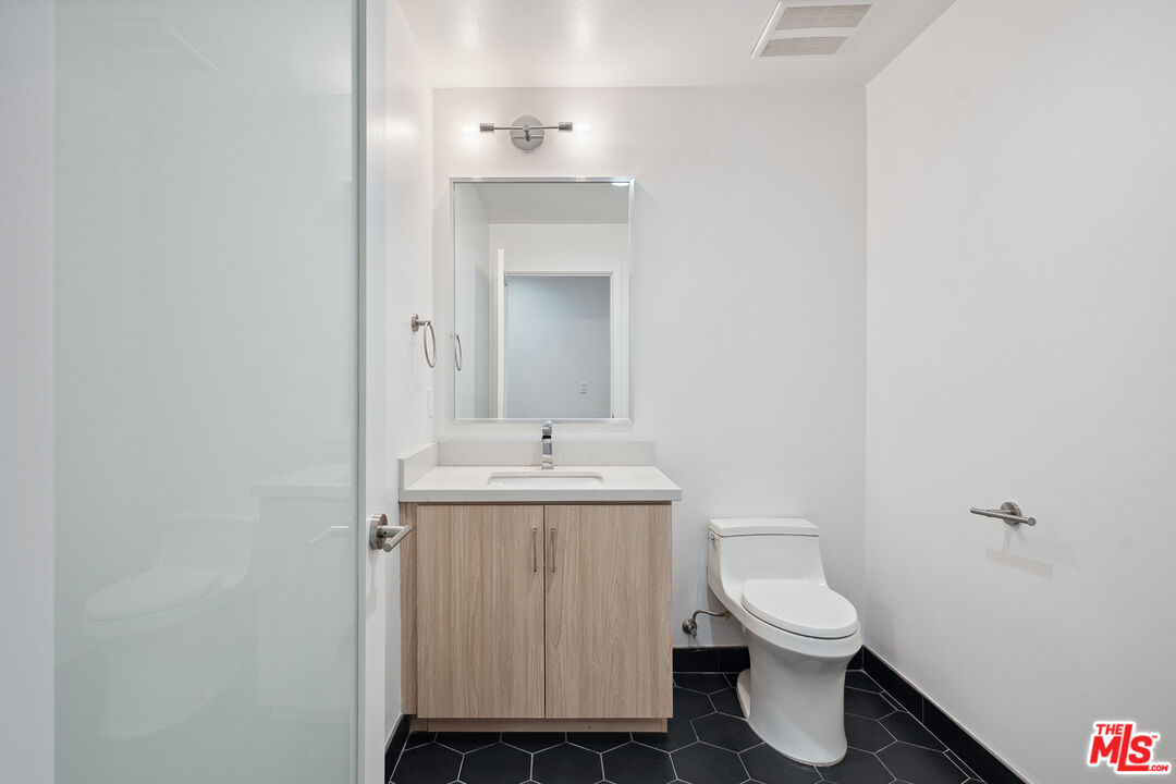 1746 Garfield Place, Unit 101 Los Angeles, CA 90028 - Photo 11 of 28 a bathroom with a toilet a sink and mirror