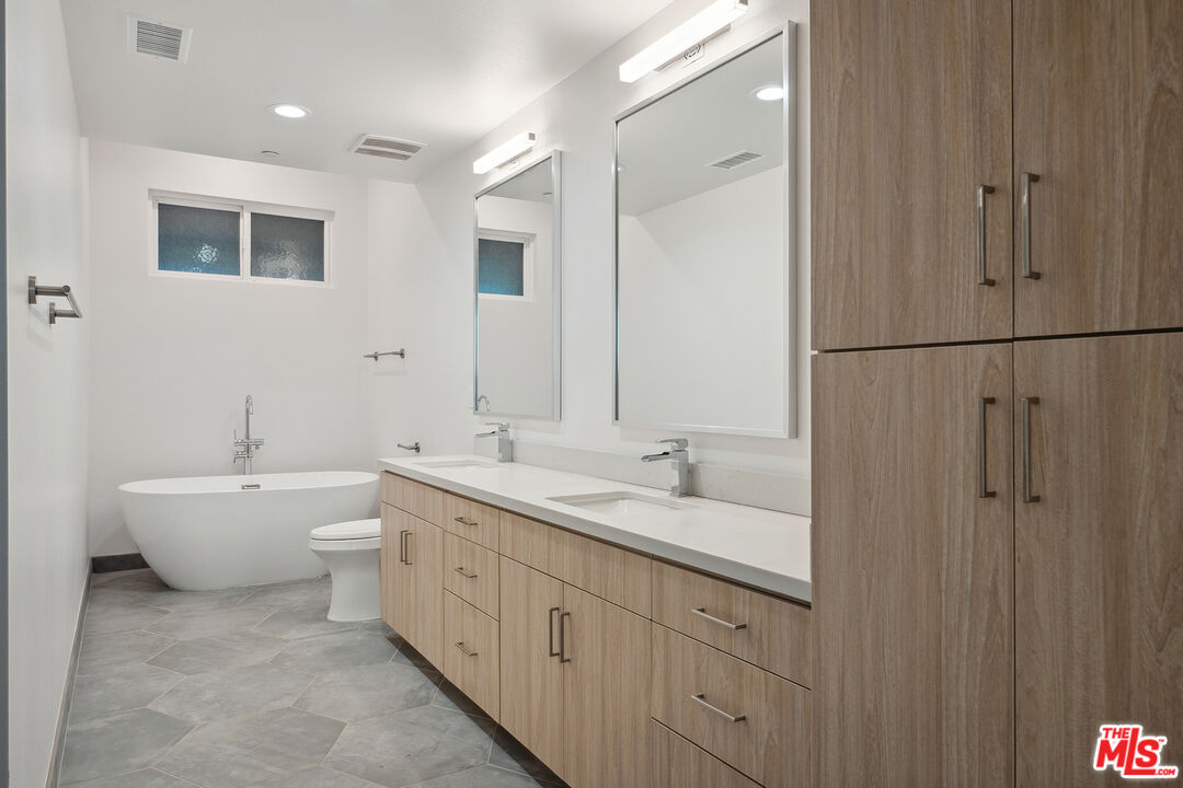 1746 Garfield Place, Unit 101 Los Angeles, CA 90028 - Photo 14 of 28 a spacious bathroom with a double vanity sink mirror and toilet