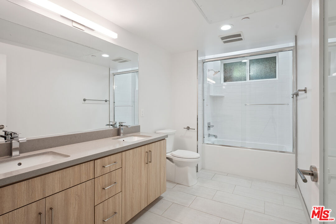 1746 Garfield Place, Unit 101 Los Angeles, CA 90028 - Photo 17 of 28 a spacious bathroom with a granite countertop sink a toilet and shower