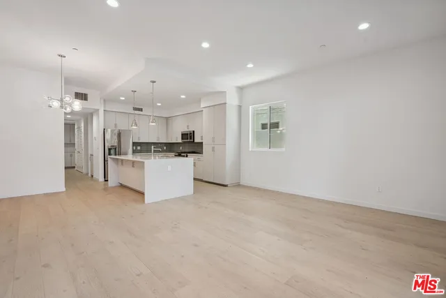a view of kitchen with refrigerator and cabinets