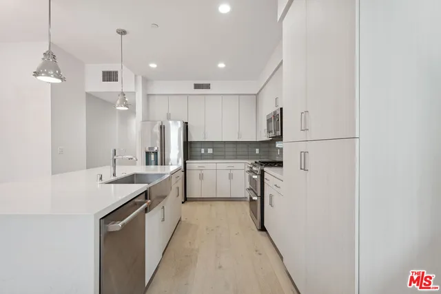 a large kitchen with kitchen island a stove a refrigerator a sink dishwasher with a dining table and chairs