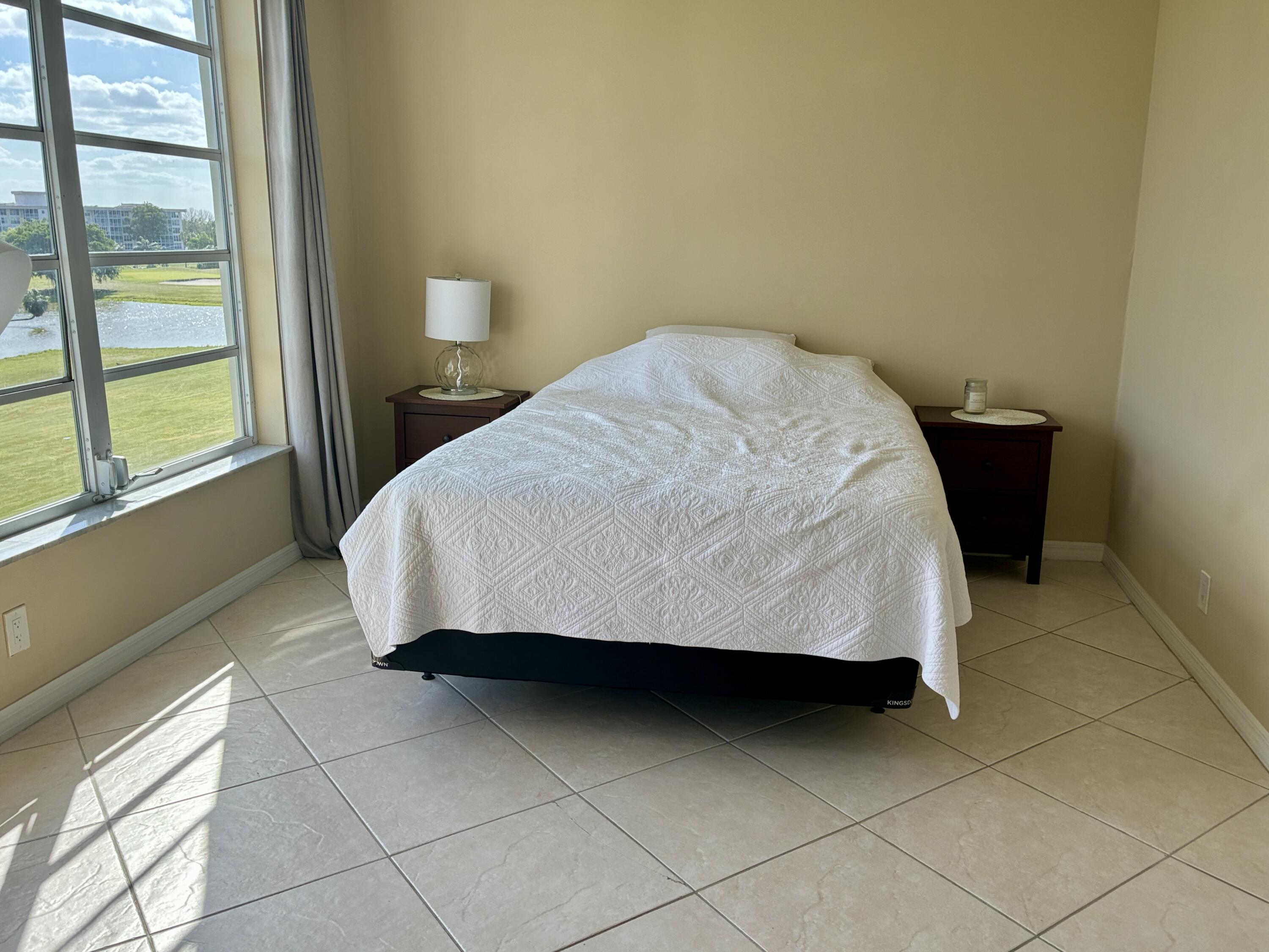 2691 South Course Drive, Unit 409 Pompano Beach, FL 33069 - Photo 14 of 22 a bedroom with a bed and a window