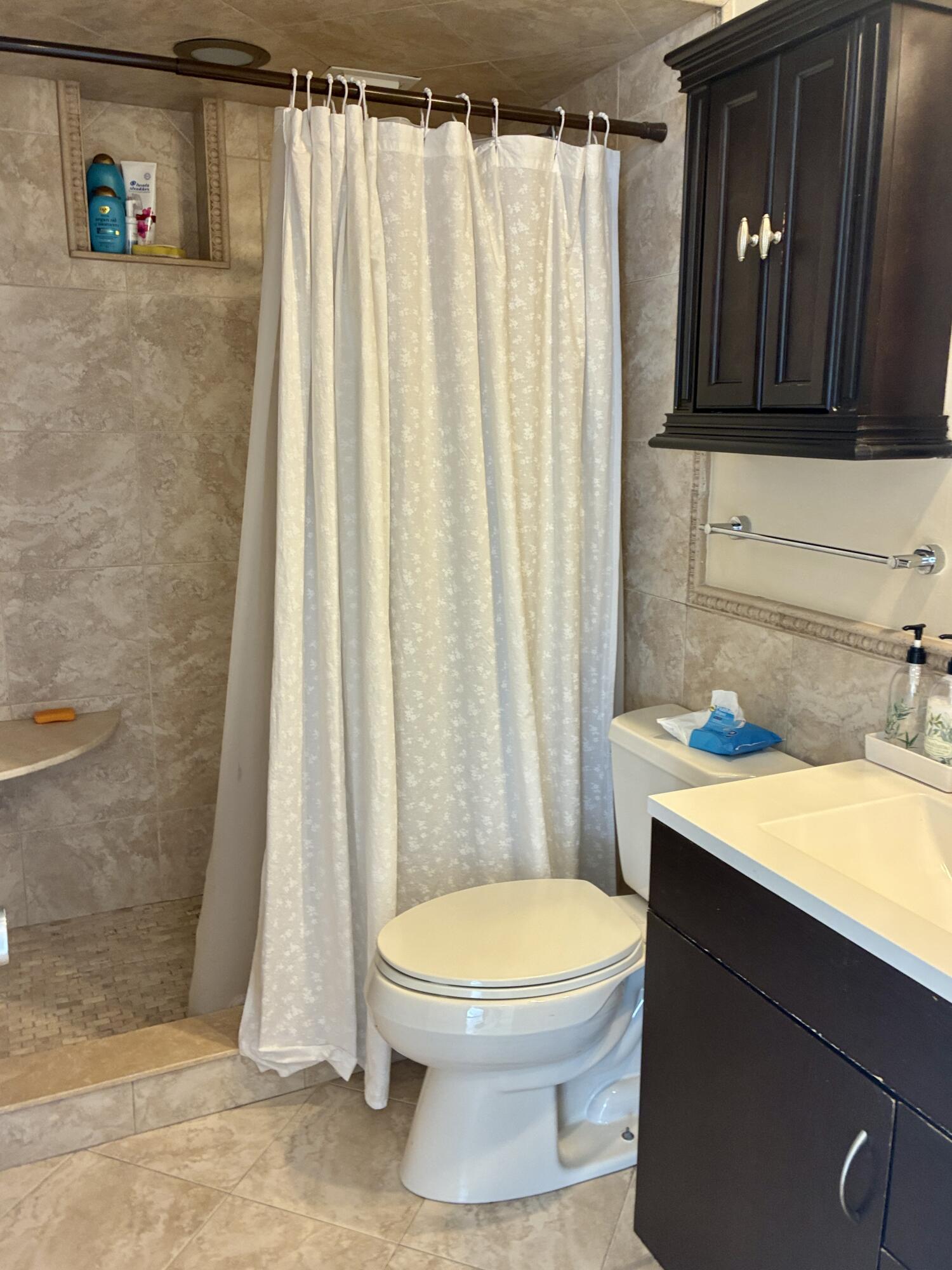 2691 South Course Drive, Unit 409 Pompano Beach, FL 33069 - Photo 16 of 22 a bathroom with a sink a toilet and shower curtain