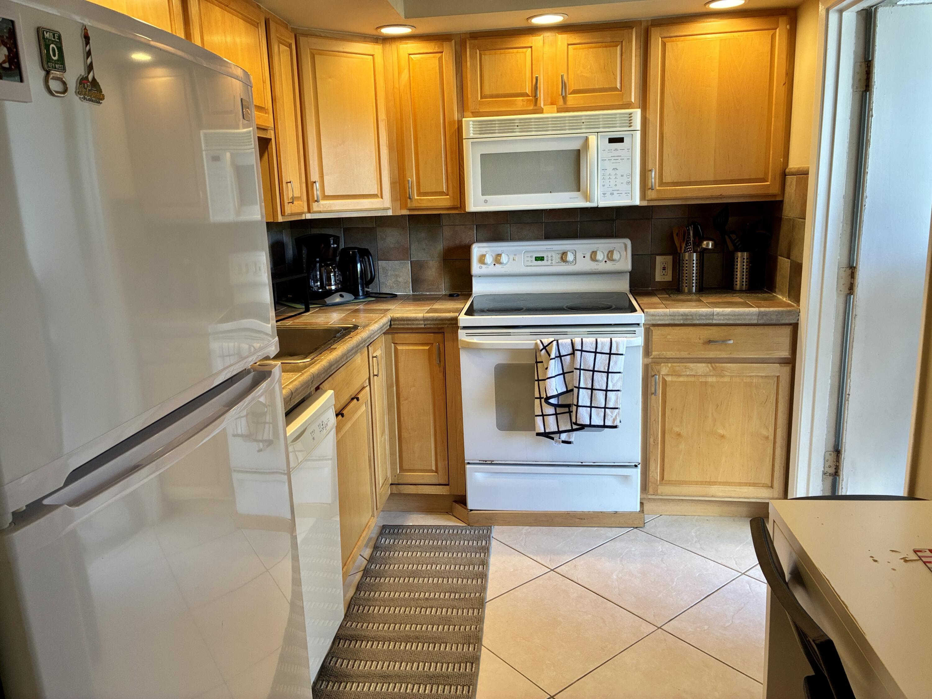 2691 South Course Drive, Unit 409 Pompano Beach, FL 33069 - Photo 5 of 22 a kitchen with stainless steel appliances granite countertop a refrigerator and a stove