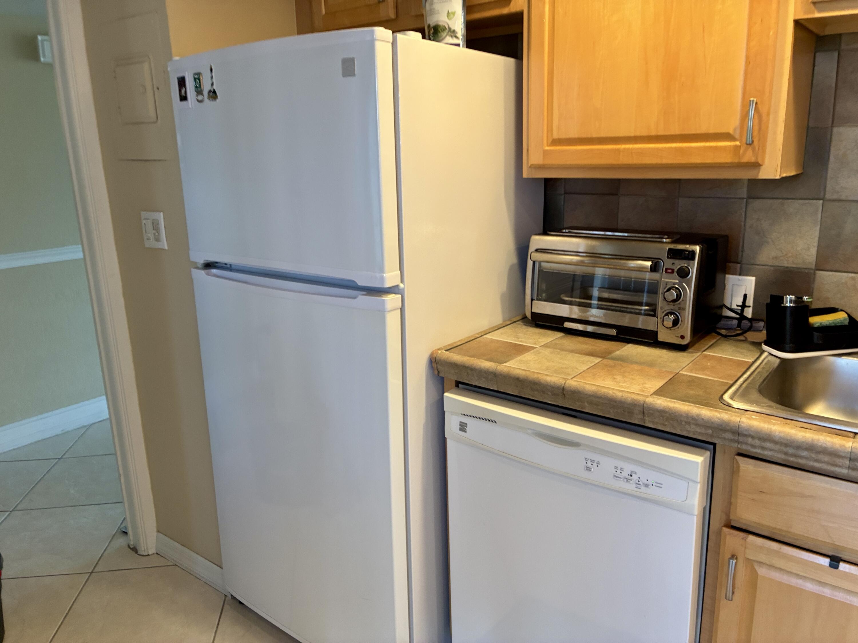 2691 South Course Drive, Unit 409 Pompano Beach, FL 33069 - Photo 6 of 22 a white refrigerator freezer sitting in a kitchen