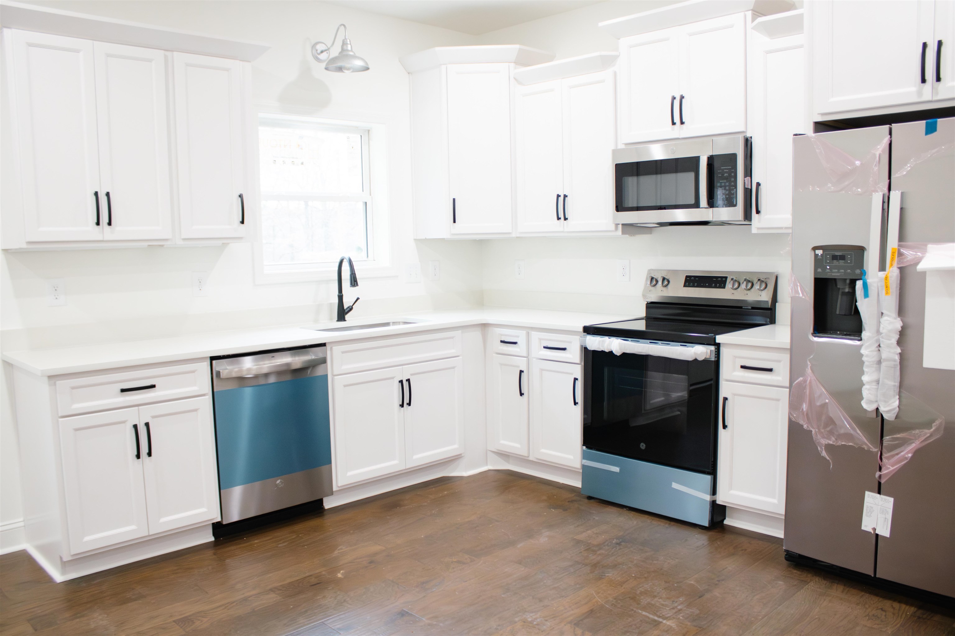 273 Oakgrove Road Selmer, TN 38375 - Photo 6 of 17 a kitchen with stainless steel appliances granite countertop white cabinets a sink a stove a microwave and cabinetry