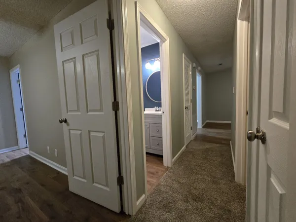 an entryway view with a hallway to other door