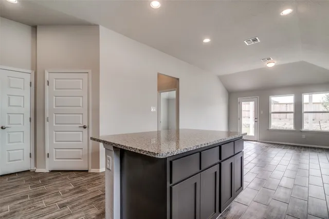 an empty room with large window and wooden floor
