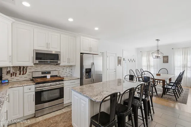 a kitchen with stainless steel appliances a stove a table a sink and a refrigerator