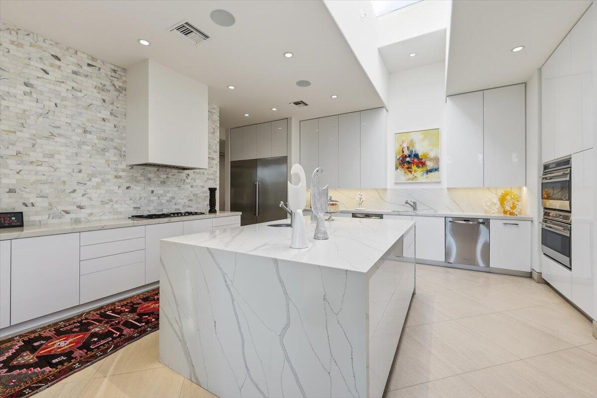 102 Waterford Circle Rancho Mirage, CA 92270 - Photo 15 of 44 a kitchen with stainless steel appliances a sink a stove a refrigerator cabinets and a dining table