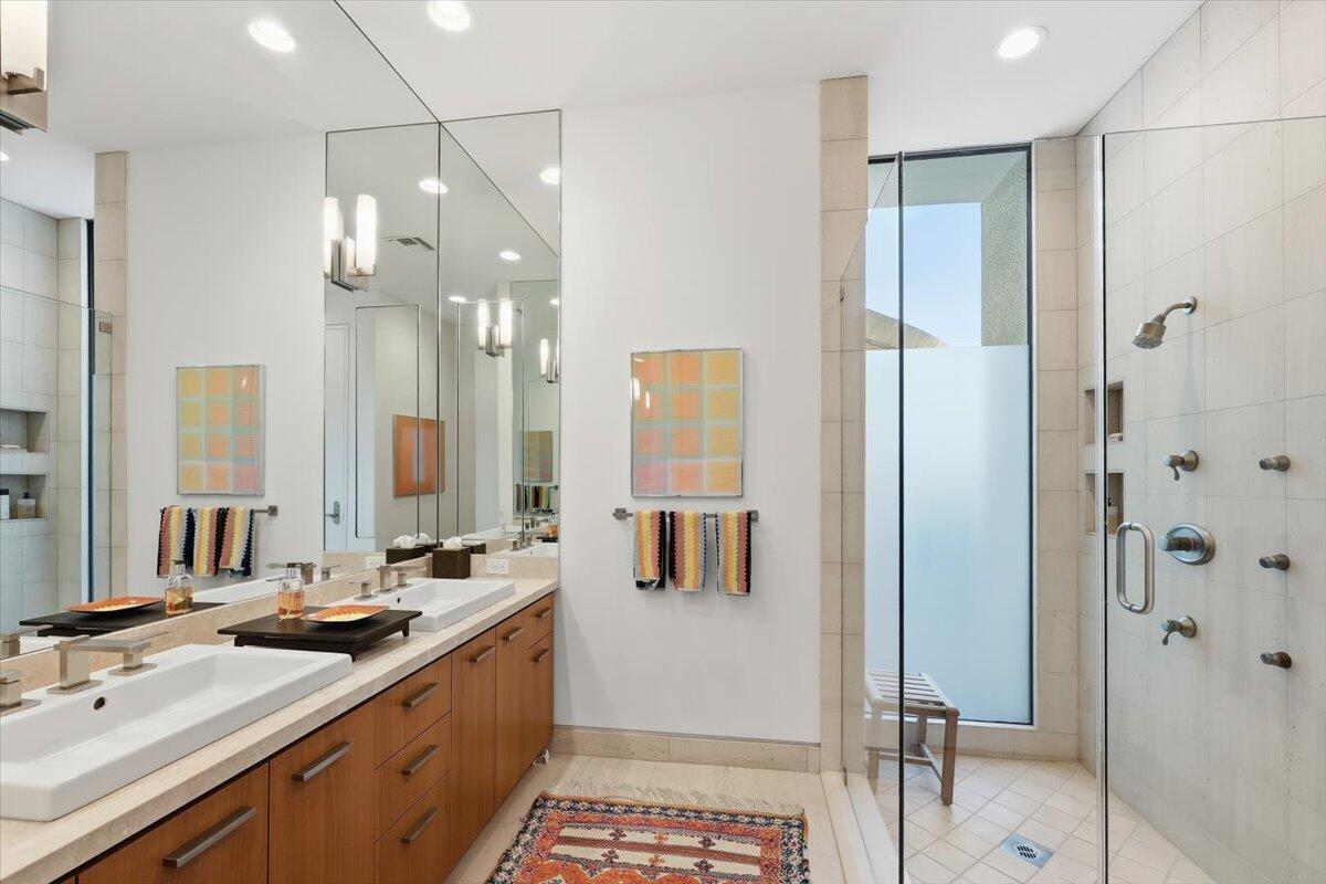 102 Waterford Circle Rancho Mirage, CA 92270 - Photo 29 of 44 a bathroom with a double vanity sink a mirror a shower and a bathtub