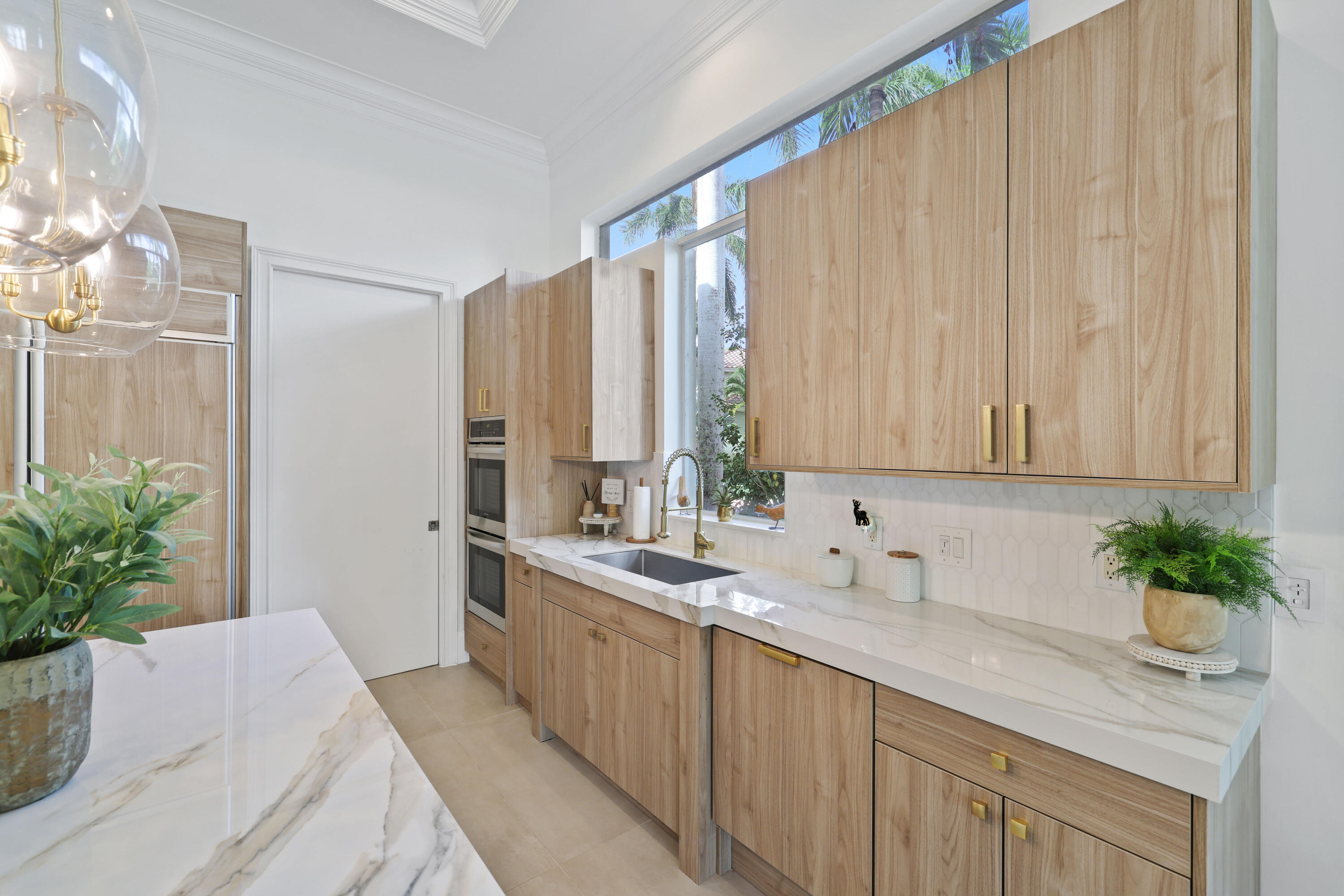 562 Rookery Place Jupiter, FL 33458 - Photo 16 of 72 a kitchen with a potted plant on the counter and cabinets