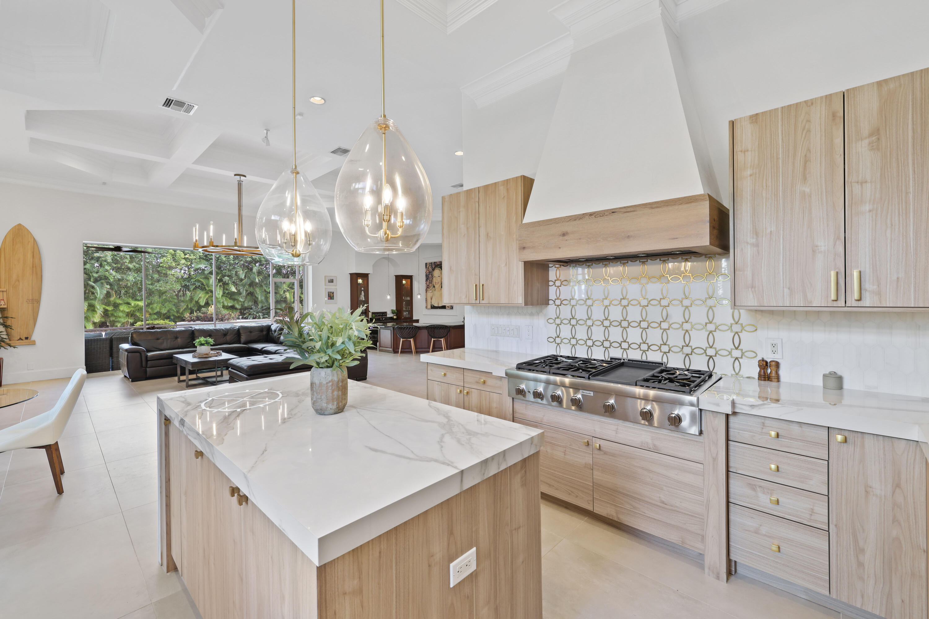 562 Rookery Place Jupiter, FL 33458 - Photo 17 of 72 a kitchen with a stove a sink a kitchen island with wooden cabinets and floor