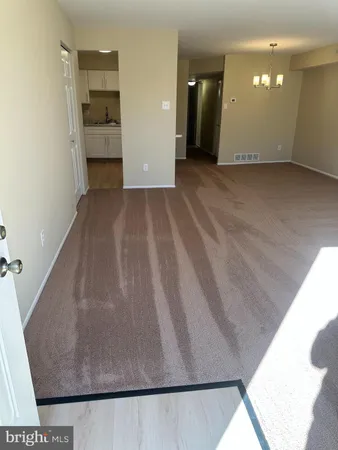 an empty room with kitchen view and mirror