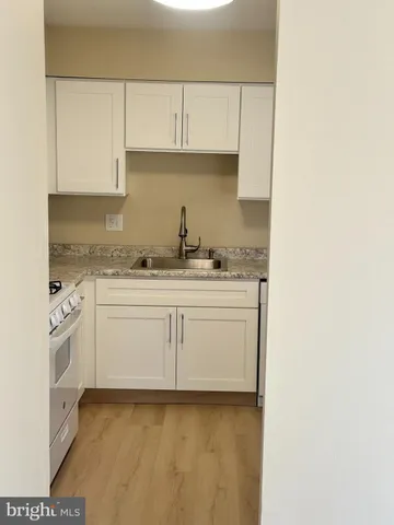 a kitchen with granite countertop sink cabinets and wooden floor