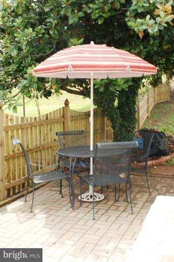 5546 Ashbourne Road Halethorpe, MD 21227 - Photo 20 of 26 a patio with a table and chairs under an umbrella
