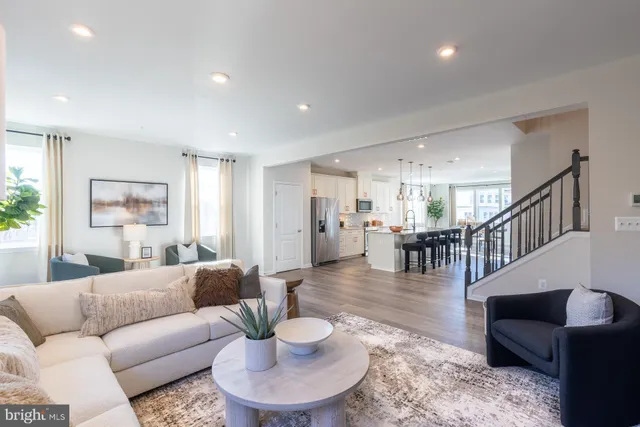 a living room with furniture and a dining table with wooden floor