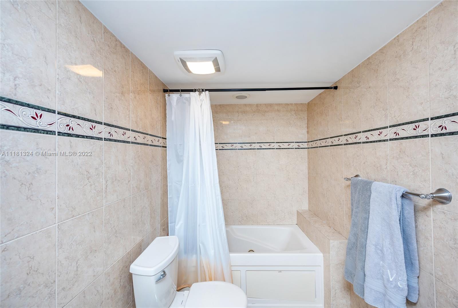 2400 Southwest 3rd Avenue, Unit 802 Miami, FL 33129 - Photo 19 of 26 a bathroom with a shower curtain and a toilet