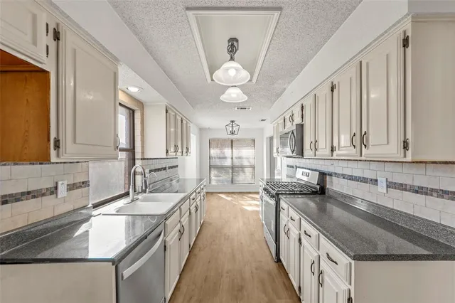 a kitchen with stainless steel appliances granite countertop a sink and stove