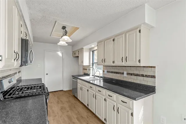 a kitchen with stainless steel appliances a stove a sink and a refrigerator