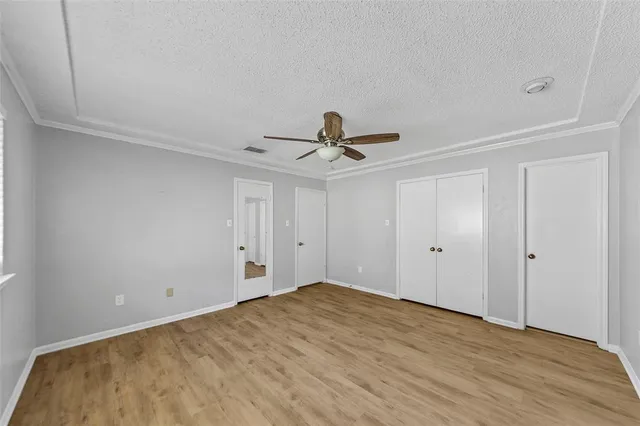 a view of a room with wooden floor and ceiling fan