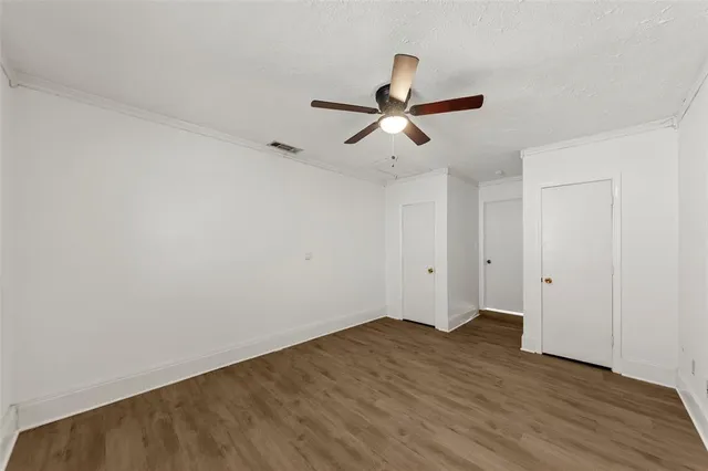 a view of a room with wooden floor and ceiling fan