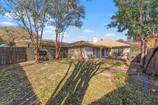 a view of a yard with plants and large trees