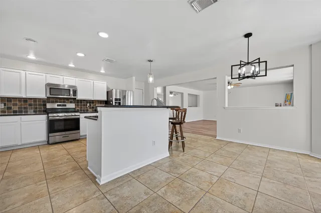 a kitchen with stainless steel appliances granite countertop a refrigerator and a stove top oven