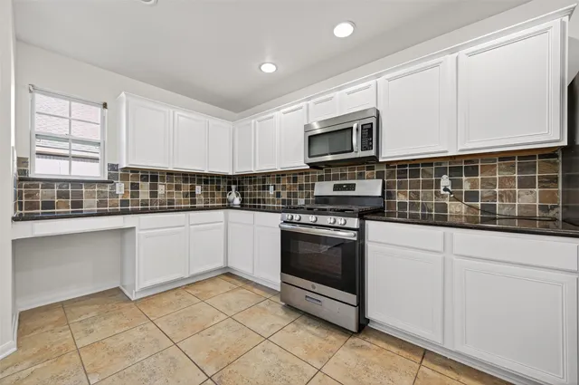 a kitchen with stainless steel appliances granite countertop a sink and a stove