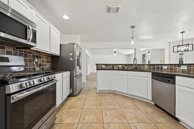 a kitchen with stainless steel appliances granite countertop a stove and a sink