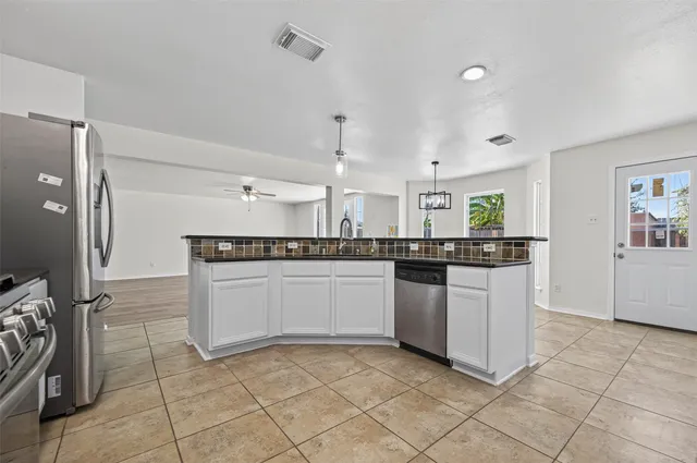 a kitchen with stainless steel appliances granite countertop a sink and cabinets