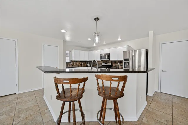 a kitchen with stainless steel appliances kitchen island a chandelier
