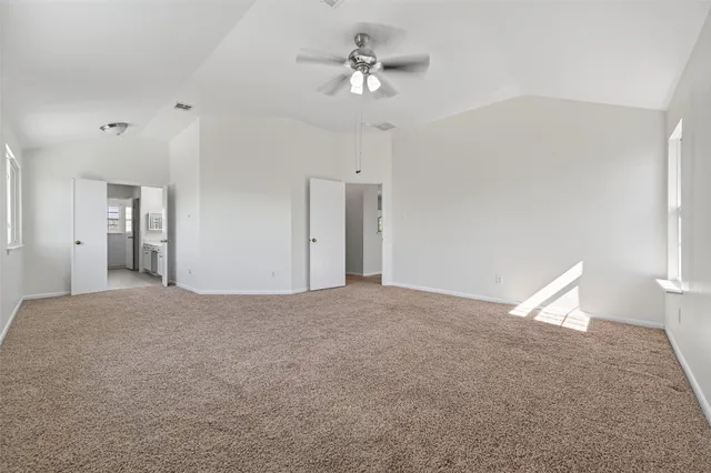 a view of a room with a ceiling fan and hardwood floor
