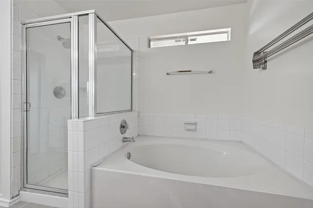 a white bath tub sitting next to a shower