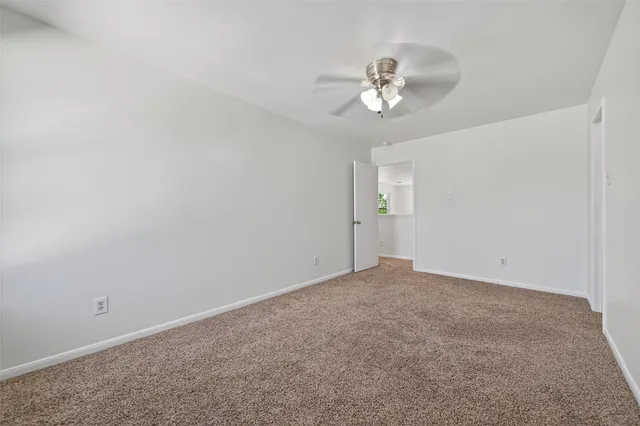 a view of an empty room with a chandelier fan