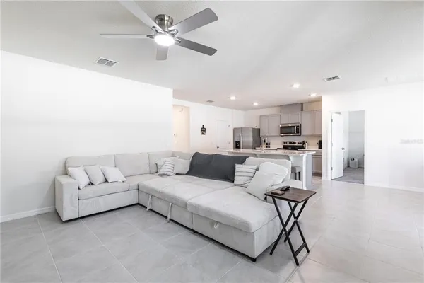 a living room with furniture and kitchen view