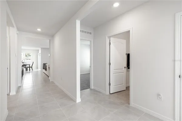 a view of a hallway with wooden floor and a living room