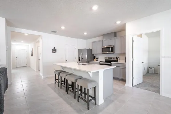 a kitchen with kitchen island granite countertop a sink and a refrigerator