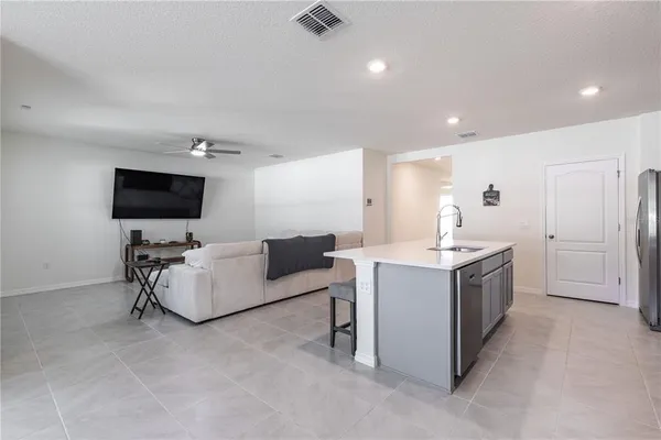 a kitchen with a sink and a stove top oven with wooden floor