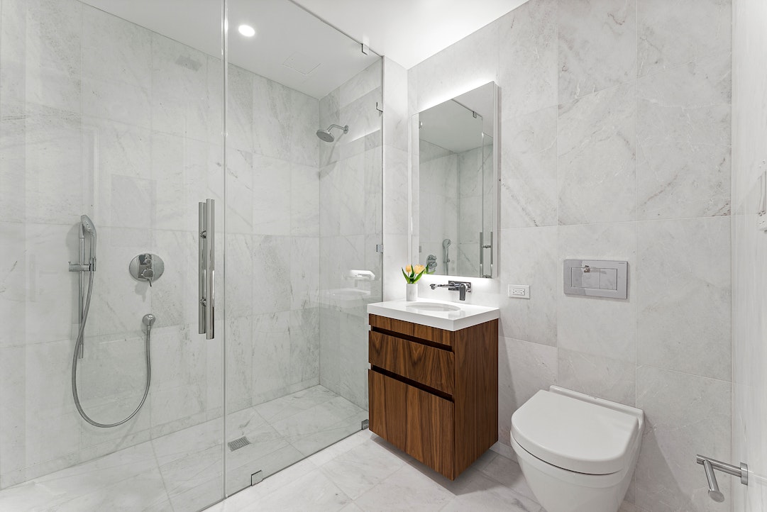 244 East 52nd Street, Unit 3C Manhattan, NY 10022 - Photo 6 of 28 a bathroom with a toilet sink and shower